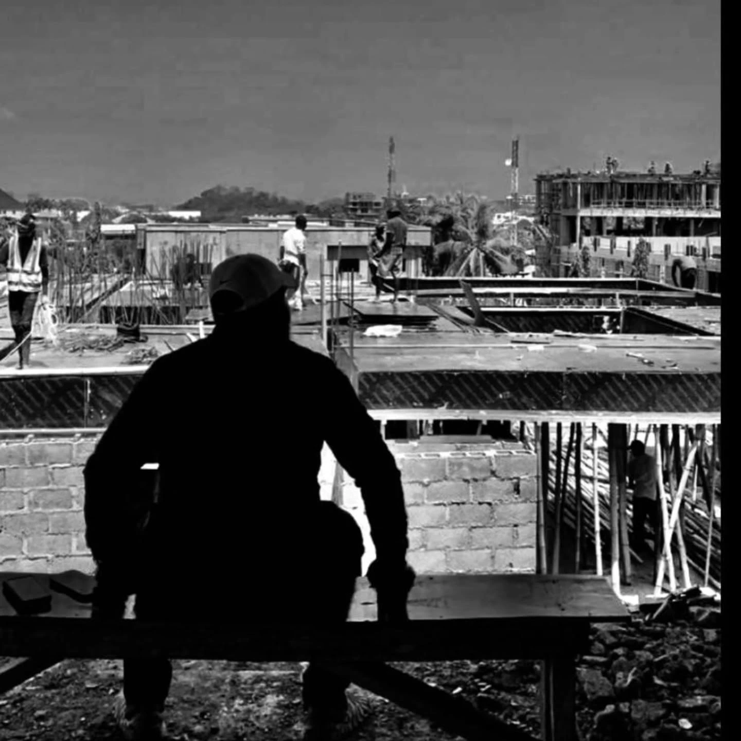 Olukayode looking out over a building site in a black and white photograph